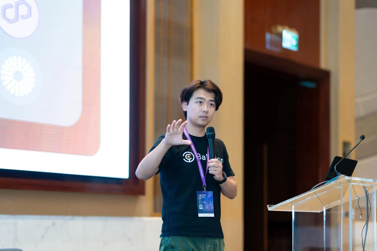 Jenks presenting on stage in a Babylon T-shirt